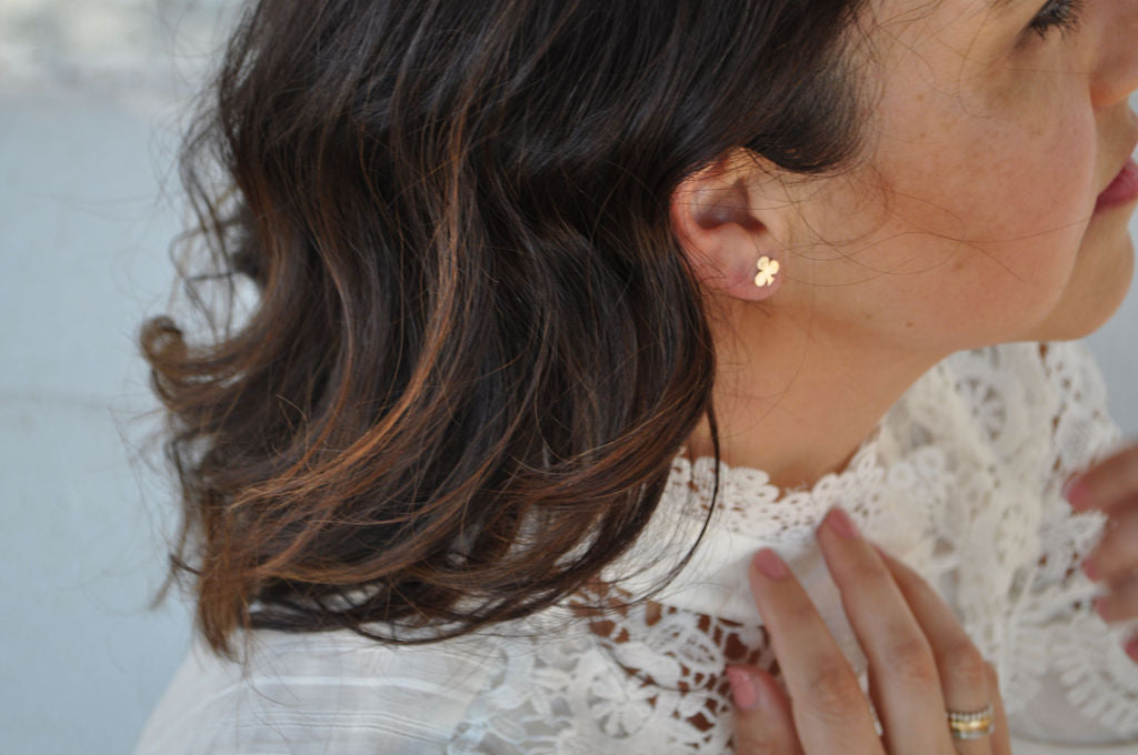 Profile of model wearing a Pharo Club sterling silver stud earring paired with a crochet top.