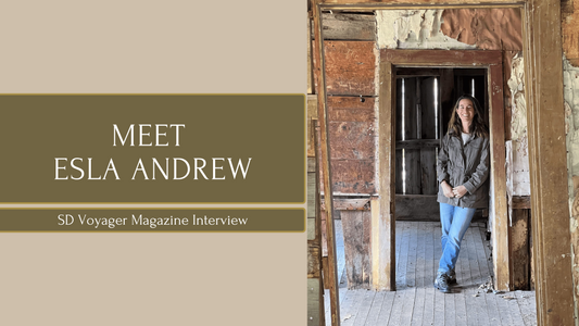 Esla Andrew standing in a rustic doorway at Animas Forks, Colorado, leaning against a weathered door frame inside a historic ghost town building