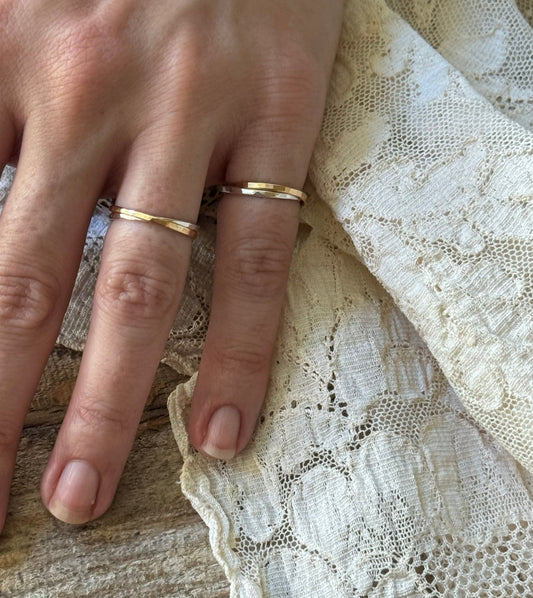 Gold-Filled and Sterling Silver Interlocking Rings on woman's hand with lace and wood background