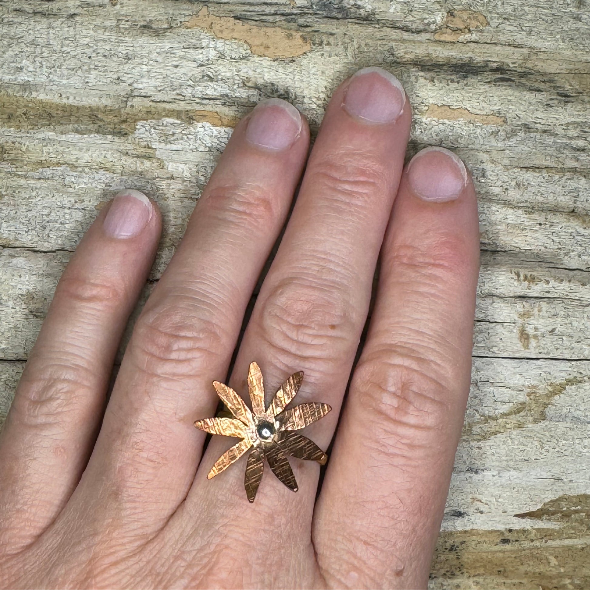 Rustic mixed metal artisan statement ring on model's hand

