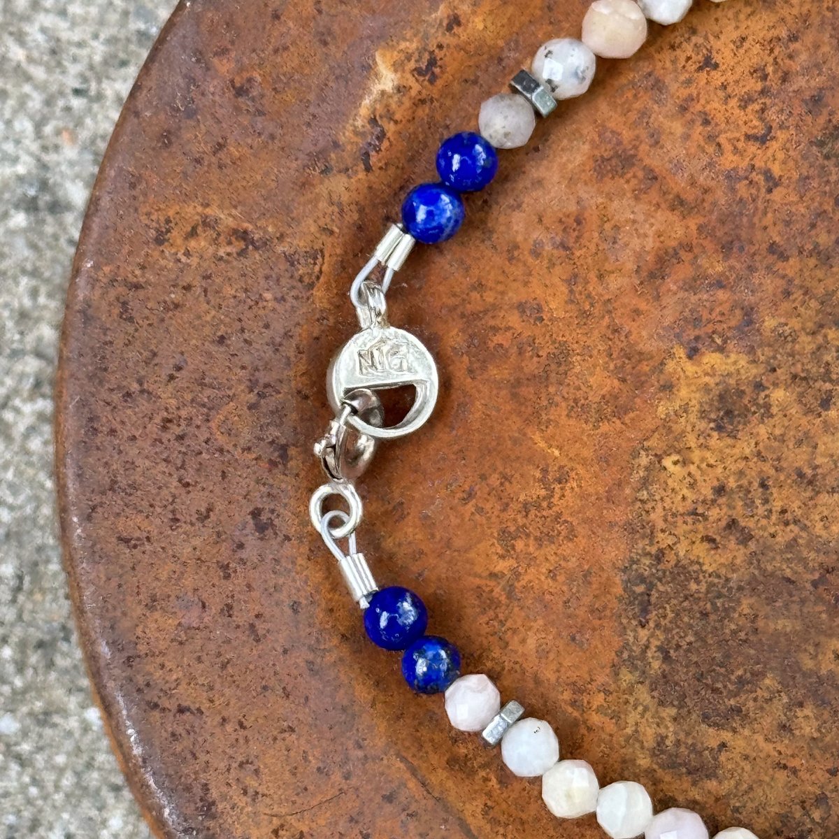 Close-up of blue Lapis beads and sterling silver clasp on a rustic background – handcrafted gemstone bracelet by Narrow-Gauge Designs
